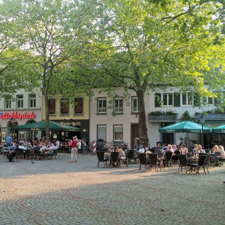 Zwei Mädchen mit Blumen im Haar lächeln, umgeben von fröhlicher Frühlingsdekoration.